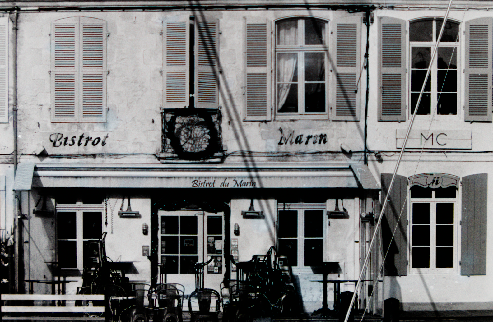 Une devanture de bar derrière des cordes de voiliers